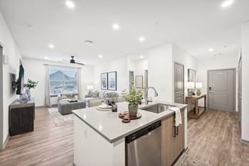 A kitchen with a large island and a living room